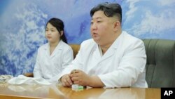 Severnokorejski lider Kim Džong Un sa ćerkom tokom posete nacionalnoj svemirskoj agenciji (Foto: Korean Central News Agency/Korea News Service via AP)