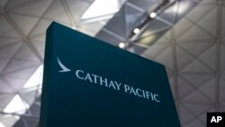 FILE - A sign for Cathay Pacific Airways at the departures hall of Hong Kong International Airport in Hong Kong, March 8, 2023. 
