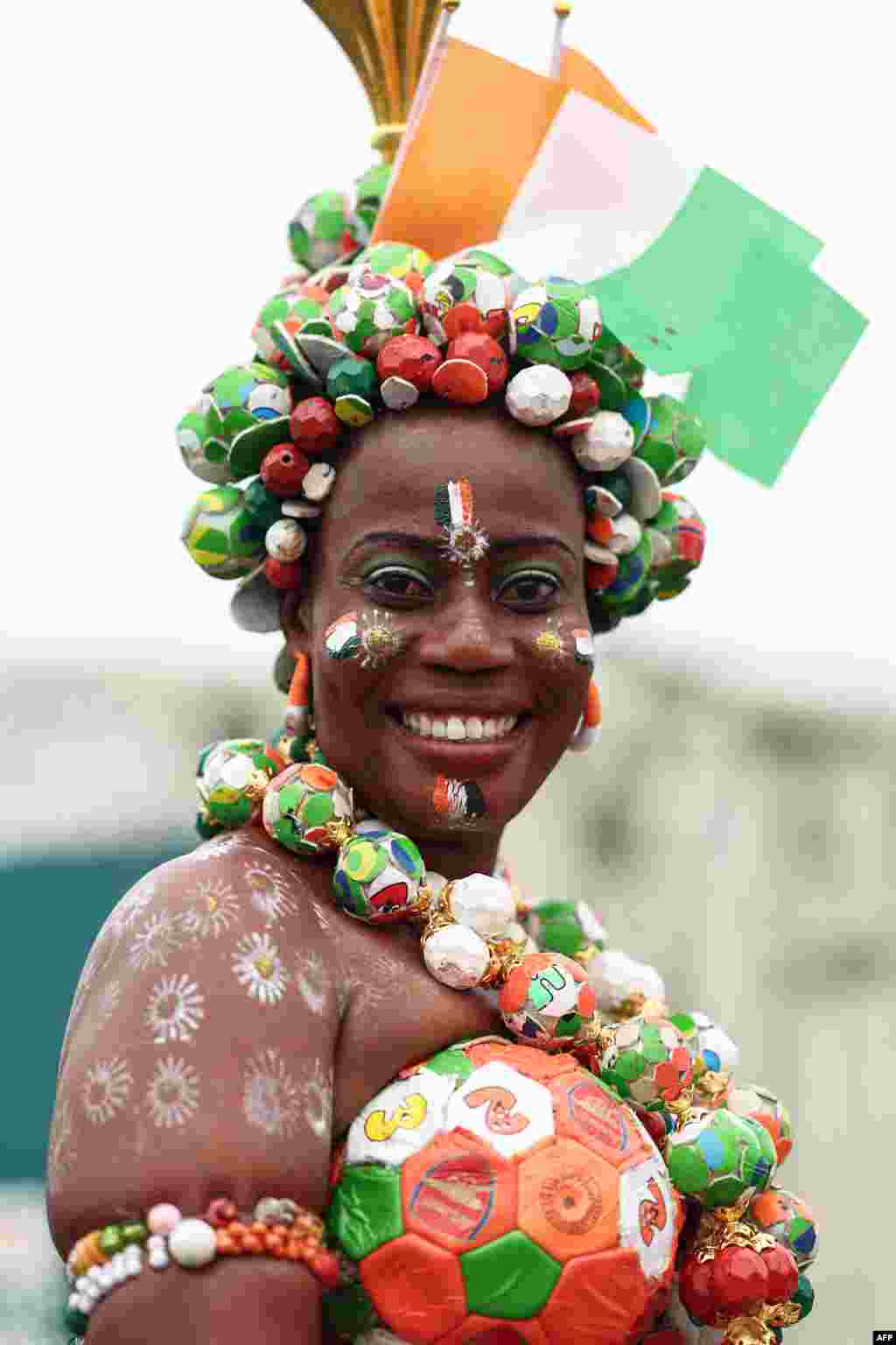 Une supportrice avec des drapeaux de la Côte d&#39;Ivoire peints sur son visage réagit avant la cérémonie d&#39;ouverture de la Coupe d&#39;Afrique des Nations (CAN) 2024 au stade olympique Alassane Ouattara à Ebimpe, Abidjan, le 13 janvier 2024.