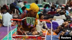 Tempat penampungan sementara bagi orang-orang yang dievakuasi dari pelabuhan Kandla, sebelum terjangan topan Biparjoy, di Gandhidham, negara bagian barat Gujarat, India, 13 Juni 2023. (Foto: Reuters)