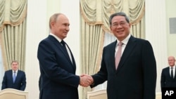 (FILE) Russian President Vladimir Putin, left, and Chinese Premier Li Qiang shake hands during their meeting at the Kremlin in Moscow, Russia, Aug. 21, 2024. 