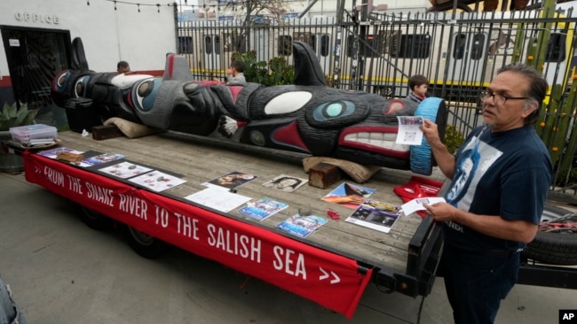 FILE - Freddie Lane, a member of the Lummi Nation, joins members of the Apache Stronghold group gathered in Los Angeles as they paint protest signs on March 20, 2023.