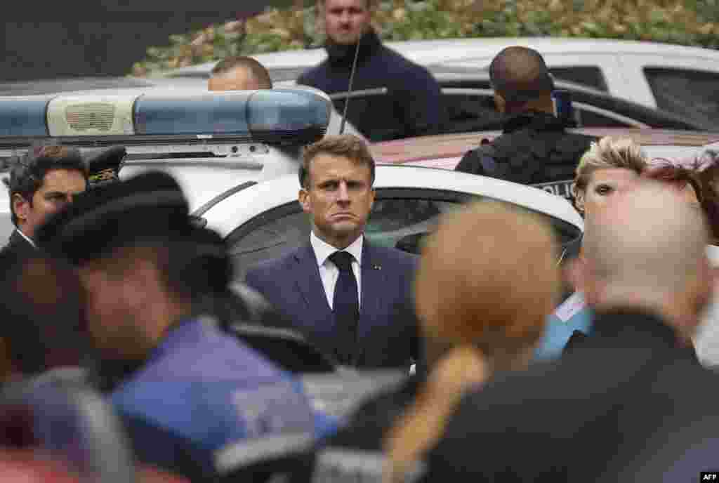 French President Emmanuel Macron, center, arrives at the Gambetta high school in Arras, northeastern France, after a teacher was killed and two other people severely wounded in a knife attack, police said. 