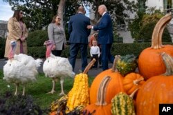 Cucu Presiden Joe Biden, Beau Biden (tengah), menyaksikan Biden (kanan), menyapa Jennie-O Turkey Store Wakil Presiden Jose Rojas (kiri tengah), setelah mengampuni kalkun Thanksgiving nasional, Liberty dan Bell, di Washington, D.C, Senin, 20 November 2023. (AP Photo/Andrew Harnik)