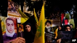 Lübnan'ın başkenti Beyrut'ta Hizbullah destekçileri ellerinde bayraklar ve Hizbullah lideri Hasan Nasrallah'ın posterleriyle protestoda, 18 Ekim 2023. 