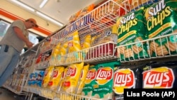 FILE - A customer makes a purchase at a convenience store in Boston in this July 12, 2005 file photo. (AP Photo/Lisa Poole, file)