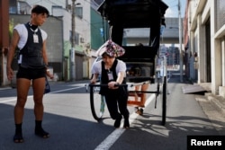 Yumeka Sakurai receives rickshaw driving lessons from her colleagues in the Asakusa district, Tokyo, Aug. 17, 2023.