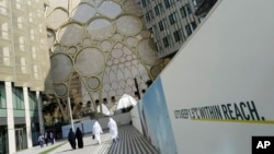 People walk near the Al Wasl Dome at Expo City ahead of the United Nations Climate Change Conference - also known as COP28 - that starts Nov. 30, 2023, in Dubai, United Arab Emirates, Nov. 28, 2023.