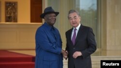 Presiden Pantai Gading Alassane Ouattara berjabat tangan dengan Menteri Luar Negeri China, Wang Yi, di kediaman kepresidenan di Abdjan, Pantai Gading, pada 17 Januari 2024. (Foto: Reuters/Stringer)