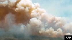 This May 31, 2023, image courtesy of the Nova Scotia Government in Canada, shows one of eight aircraft from New Brunswick that drops a mix of water and fire retardant making a pass over the fire near Barrington Lake, Shelburne County. 