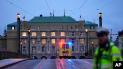 FILE - A police officer guards a street in downtown Prague, Czech Republic, on Dec. 21, 2023, following a deadly shooting. 