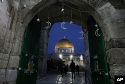 Muslims walk next to the Dome of Rock Mosque at the Al-Aqsa Mosque compound in Jerusalem's Old City, March 10, 2024.