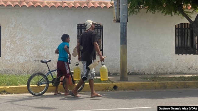 Un hombre lleva gasolina a revendedores de combustible en la calle 43 de Maracaibo, en el estado occidental venezolano de Zulia.