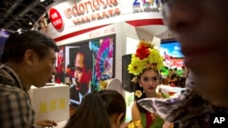 FILE - Seorang perempuan mengenakan kostum tradisional Bali membagikan brosur promosi pariwisata untuk pengunjung di booth Indonesia, Beijing International Tourism Expo di Beijing, 16 Juni 2017. (AP/Mark Schiefelbein)