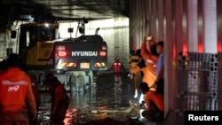 Rescue workers take part in a search and rescue operation inside an underpass that has been submerged by a flooded river caused by torrential rain in Cheongju, South Korea, July 17, 2023. (Yonhap via Reuters)