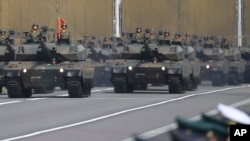 FILE - The Japan Ground Self-Defense Force tanks parade during the Self-Defense Forces Day at Asaka Base in Asaka, north of Tokyo, on Oct. 23, 2016.