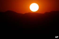 The setting sun colors the sky orange as four wildland fires burn in Colorado Aug. 1, 2024.