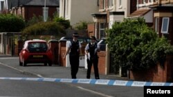 Police officers walk near the scene in Hart street where a man was arrested after people were stabbed in Southport, Britain, July 30, 2024. 