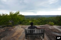 A man sits on a bench at the Matopos World Heritage site on the outskirts of Bulawayo, Zimbabwe, on Feb, 11, 2023.