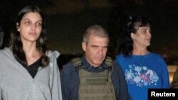 Judith Raanan and daughter Natalie Raanan, U.S. citizens who were Hamas hostages, walk with retired Brig. Gen. Gal Hirsch, Israel's coordinator for the captives and missing, after their release, in this handout photo, Oct. 20, 2023.