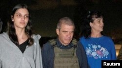 Judith Tai Raanan and daughter Natalie Shoshana Raanan, U.S. citizens who were Hamas hostages, walk with retired Brig. Gen. Gal Hirsch, Israel's coordinator for the captives and missing, after their release, in this handout picture, Oct. 20, 2023.