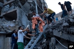 Los palestinos rescatan a una niña de los escombros de un edificio residencial destruido tras un ataque aéreo israelí, el martes 10 de octubre de 2023.