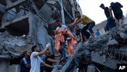 Warga Palestina menyelamatkan seorang anak perempuan dari reruntuhan bangunan tempat tinggal yang hancur akibat serangan udara Israel, hari Selasa, 10 Oktober 2023.