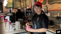 Christopher Au, 19, dishes out ice cream at a J.P. Licks in Boston’s Beacon Hill neighborhood on Thrusday, May 25, 2023. (AP Photo/Steve LeBlanc)