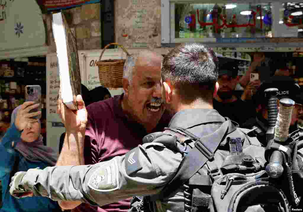 A man holds a copy of the Quran as Israeli police blockade the entrance to the Al-Aqsa Mosque compound following a visit to the site by Israel&#39;s hard-right National Security Minister Itamar Ben-Gvir, in Jerusalem&#39;s Old City.