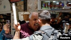 A man holds a copy of the Quran as Israeli police blockade the entrance to the Al-Aqsa Mosque compound following a visit to the site by Israel&#39;s hard-right National Security Minister Itamar Ben-Gvir, in Jerusalem&#39;s Old City.