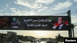 Vehicles drive past a billboard in Cairo for presidential candidate and current Egyptian President Abdel Fattah el-Sissi, on Dec. 9, 2023, the first day of voting in the presidential election.
