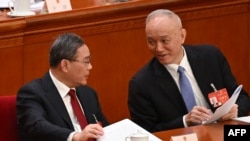 中國總理李強（左）與中共中央政治局常委蔡奇在北京人大會堂的全國人大會議開幕式上。（2024年3月5日）