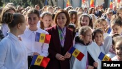 FILE - Moldovan President Maia Sandu meets with children during a ceremony marking the National Flag Day in Chisinau, April 27, 2024. 