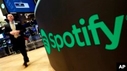 FILE - A trading post sports the Spotify logo on the floor of the New York Stock Exchange, April 3, 2018. Spotify said Monday, Dec. 4, 2023 it's cutting 17% of its global workforce as it tries to slash costs while focusing on profitabilty.