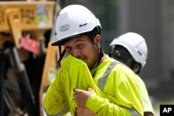 FILE - Construction worker Fernando Padilla wipes his face as he works in the heat on June 30, 2023 in Nashville, Tenn. (AP Photo/George Walker IV, File)