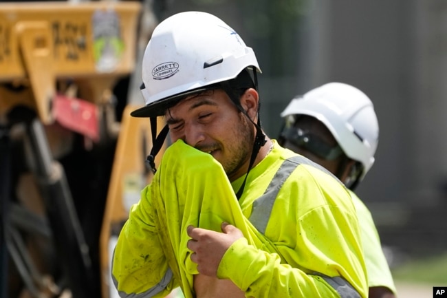 FILE - Construction worker Fernando Padilla wipes his face as he works in the heat on June 30, 2023 in Nashville, Tenn. (AP Photo/George Walker IV, File)