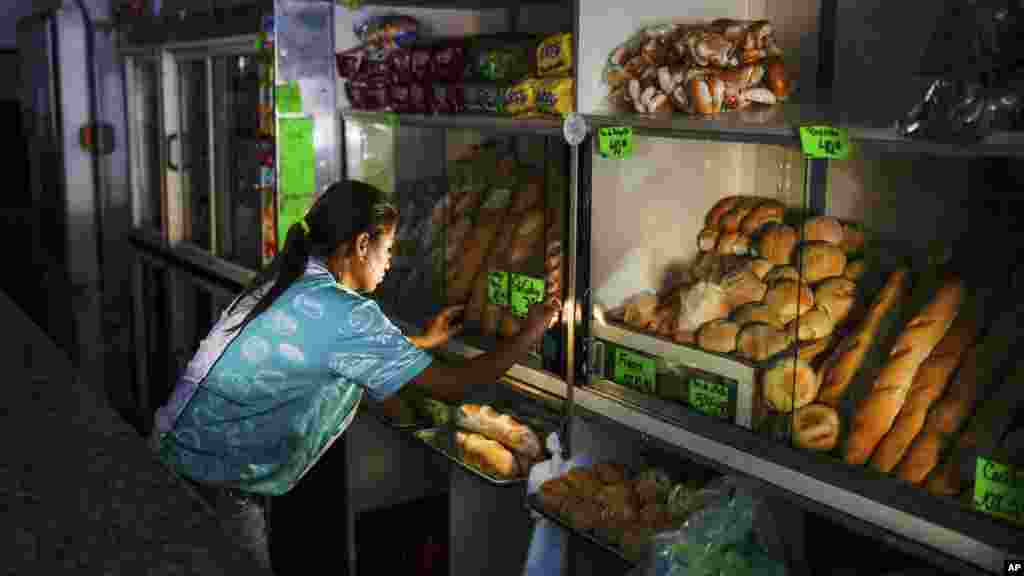 A bakery worker makes adjustments at the shop during a blackout in Caracas, Venezuela.