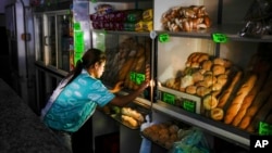 A bakery worker makes adjustments at the shop during a blackout in Caracas, Venezuela.