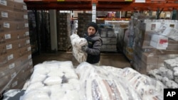 Driver Carlos Quezada loads rice on a pallet for distribution at Feeding Westchester in Elmsford, NY, Nov. 15, 2023.