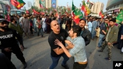 Pakistani police detain supporter of former Prime Minister Imran Khan's political party, Pakistan Tehreek-e-Insaf (PTI), during an election campaign rally in Karachi, Pakistan, Jan. 28, 2024.