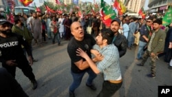 Pakistani police detain a supporter of former Prime Minister Imran Khan's Pakistan Tehreek-e-Insaf party (PTI), during a campaign rally in Karachi, Jan. 28, 2024.