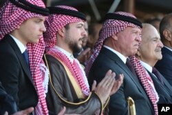 Putra Mahkota Yordania Hussein (kedua dari kiri), duduk di sebelah ayahnya, Raja Abdullah II (ketiga dari kiri), dalam sebuah perayaan di Amman, Yordania, Rabu, 31 Mei 2023, sehari sebelum pernikahannya dengan arsitek Saudi Rajwa Alseif. (AP/Raad Adayleh)