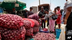 People buy onions at an open market in Nairobi, Kenya, Sept. 12, 2023. Restrictions on the export of the vegetable by neighboring Tanzania has led prices to triple. Some traders have adjusted by getting produce from Ethiopia. 