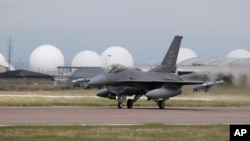 FILE - A F-16 Fighting Falcon from Colorado Air National Guard's 140th Wing takes off from Buckley Air Force Base as part of a second flyover to salute COVID-19 front line workers, May 15, 2020, in Aurora, Colo. 