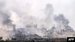 A picture taken from southern Israel near the border with the Gaza Strip on Dec. 10, 2023, shows smoke rising above buildings during Israeli bombardments on Khan Yunis. 