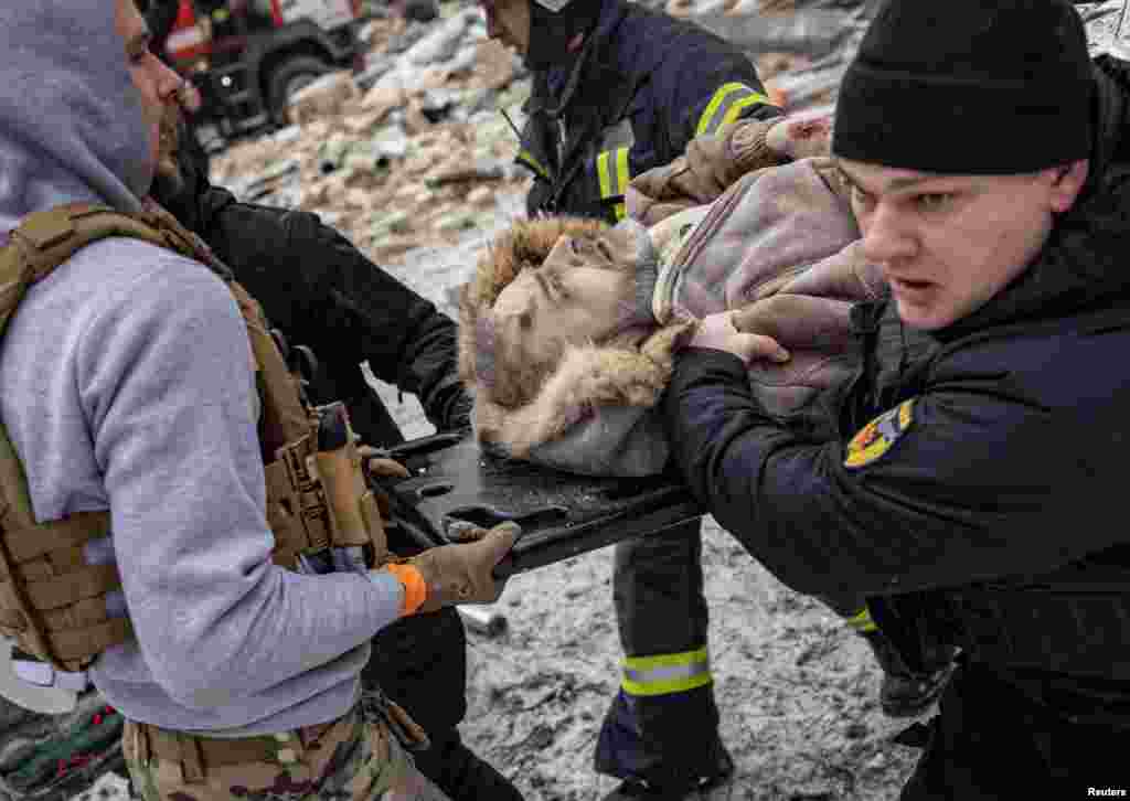 Поліція евакуює місцевого мешканця житлового будинку у Харкові, зруйнованого російською ракетною атакою.&nbsp;Фото&nbsp;REUTERS/Євген Титов,&nbsp;зроблено&nbsp;23 січня 2024 року