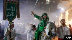 An Iraqi Shiite boy takes part in a mourning ritual in central Baghdad, July 27, 2023, in the lead-up to Ashura, a 10-day period commemorating the 7th- century killing of the Prophet Muhammad's grandson Imam Hussein.