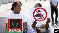 Demonstrators hold signs during a rally on the opening day of peace talks for Sudan at the Place des Nations in front of the European headquarters of the United Nations in Geneva, Aug. 14, 2024.