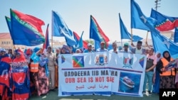 FILE - Demonstrators in Mogadishu hold banners and flags in support of Somalia's government on Jan. 3, 2024, following the port deal signed between Ethiopia and the breakaway region of Somaliland.