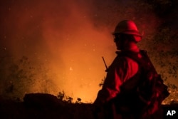 A firefighter from the city of Monterey monitors flareups from the Park Fire near Butte Meadows, Calif., Sunday, July 28, 2024. (AP Photo/Nic Coury)